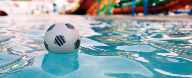 Image of an empty community pool with a ball floating in the swimming pool.